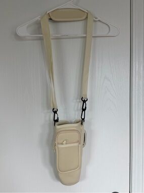 Crossbody water bottle cream bag adjustable straps 2 pockets holds up to 40 oz